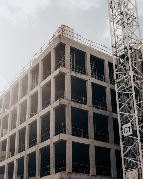 Concrete building frame beside a tower crane