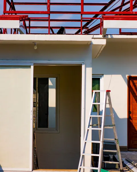 House exterior with scaffolding and a ladder during renovation